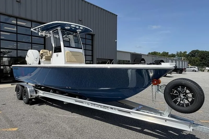 Slide: The Image of 2027 Sportsman Masters 247 Bay Boat on trailer, parked outside a modern building. - 7