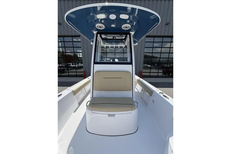 Slide: The Image of 2027 Sportsman Masters 247 Bay Boat interior with seating and console under a blue canopy. - 24