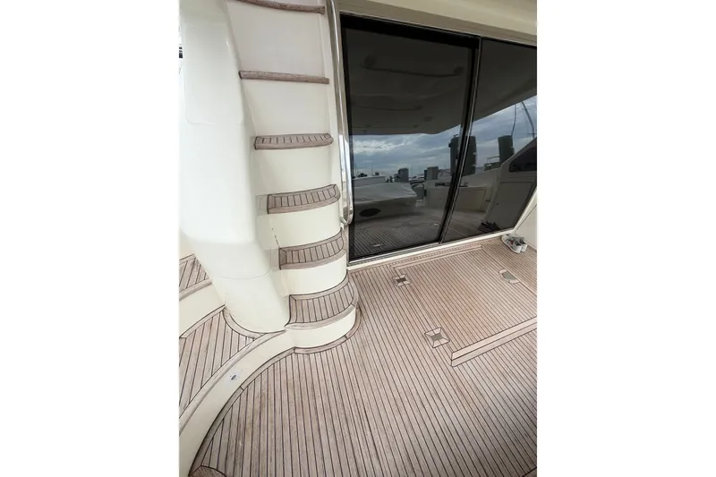 Slide: The Image of 2006 Azimut 55E yacht deck with wooden flooring and sleek design elements. - 44