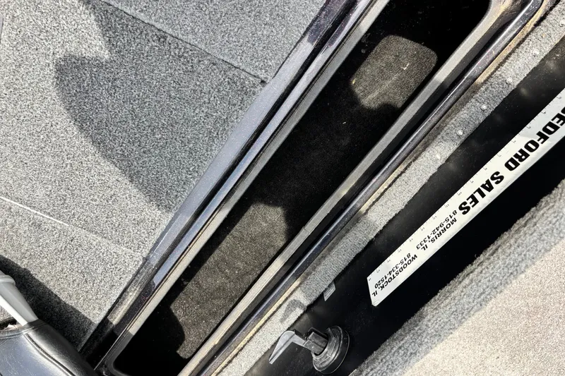Slide: The Image of Interior view of a 1997 Stratos 282 DC boat, showcasing carpeted flooring and storage compartment. - 4
