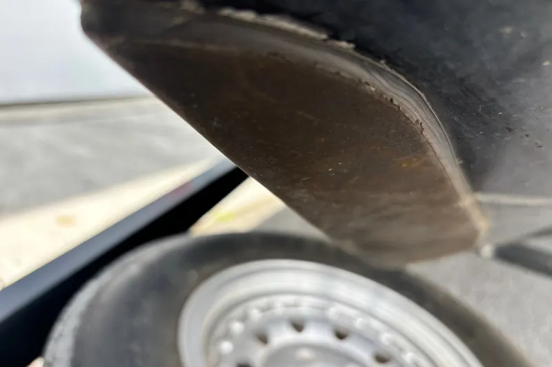 Slide: The Image of Close-up of a 1997 Stratos 282 DC boat hull and trailer wheel. - 2