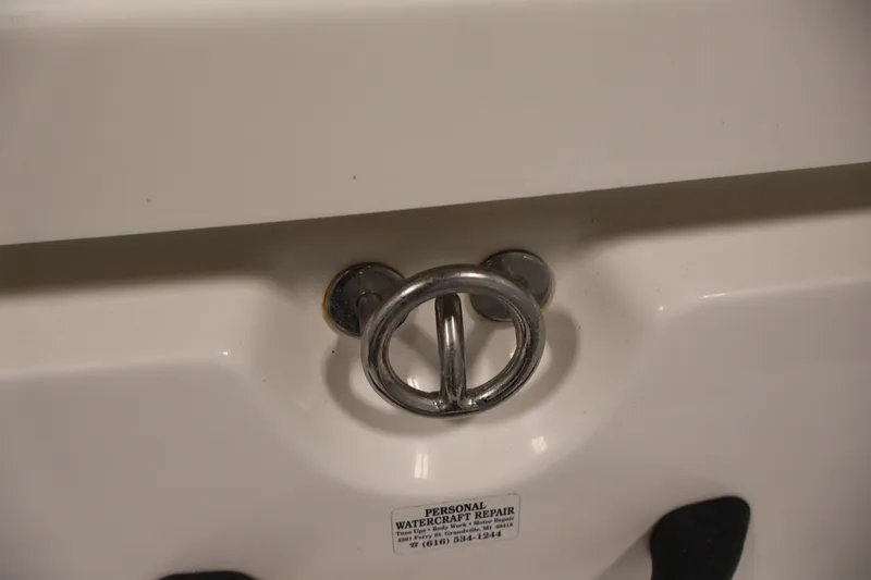 Slide: The Image of Close-up of a 2011 Sea-Doo Challenger 180 boat's metal latch and repair label. - 32