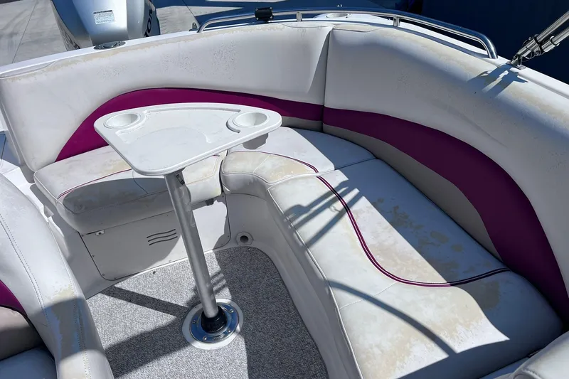 Slide: The Image of 2005 Hurricane FunDeck GS 202 OB boat interior with white and purple seating and a small table. - 9