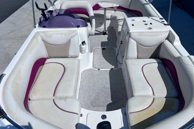 Slide: The Image of 2005 Hurricane FunDeck GS 202 OB interior with white and purple seating, table, and storage. - 6