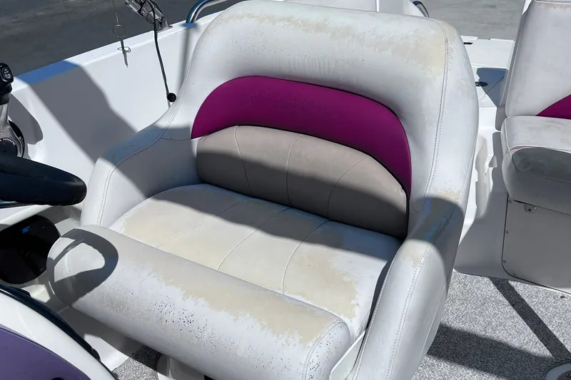 Slide: The Image of Captain's seat on a 2005 Hurricane FunDeck GS 202 OB boat, featuring white and purple upholstery. - 10
