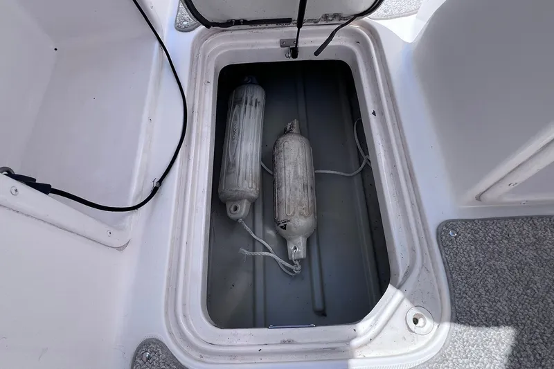 Slide: The Image of Storage compartment on a 2005 Hurricane FunDeck GS 202 OB boat with two fenders inside. - 18