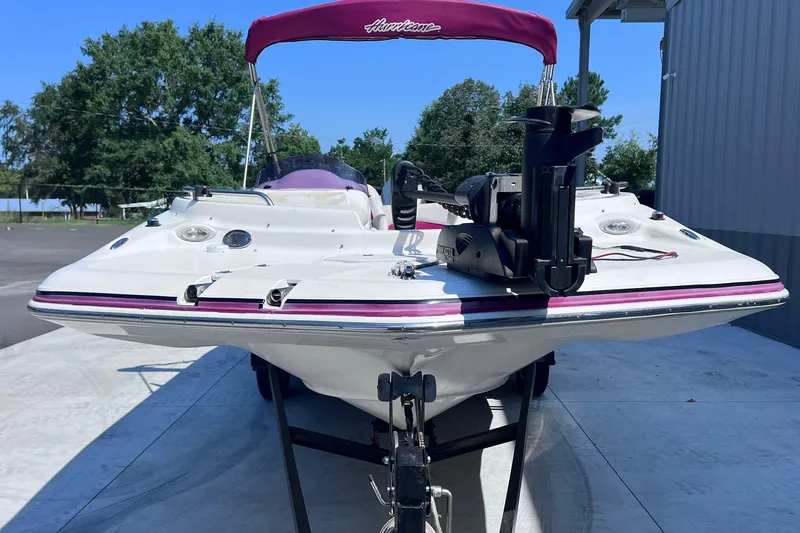 Slide: The Image of 2005 Hurricane FunDeck GS 202 OB boat with purple canopy on trailer, parked outdoors. - 4