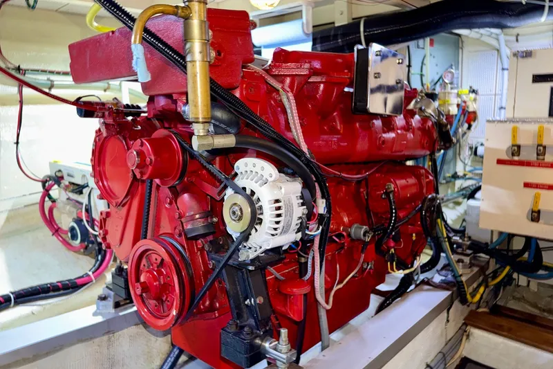 Slide: The Image of Engine room of 1988 Grand Banks 42 Classic, featuring a red marine engine. - 73