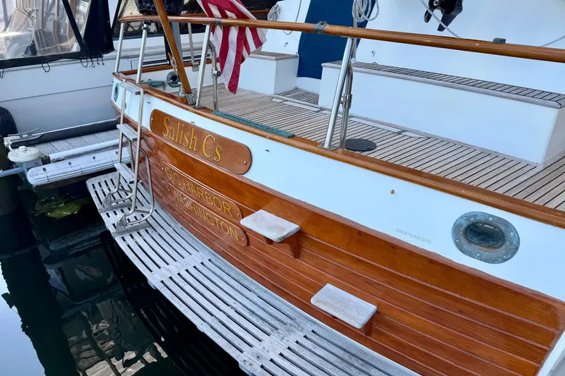 Slide: The Image of Grand Banks 42 Classic 1988 yacht docked, featuring wooden deck and American flag. - 17