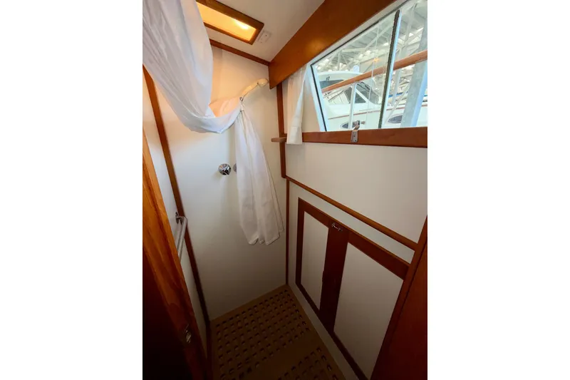 Slide: The Image of Shower area in 1988 Grand Banks 42 Classic yacht with wooden accents and window. - 61