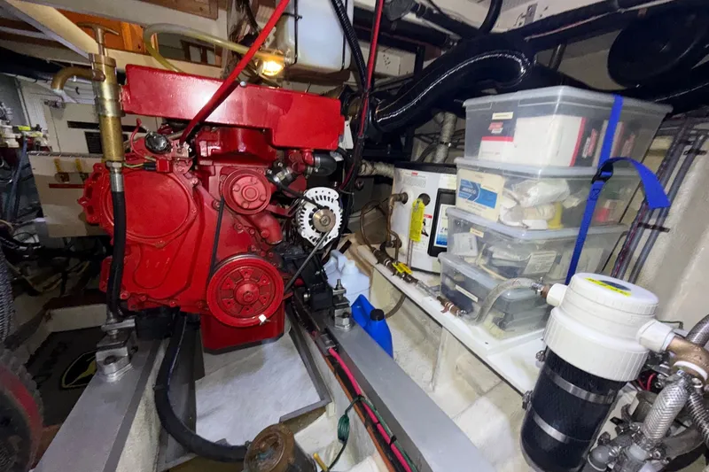 Slide: The Image of Engine room of 1988 Grand Banks 42 Classic with red engine and storage boxes. - 71