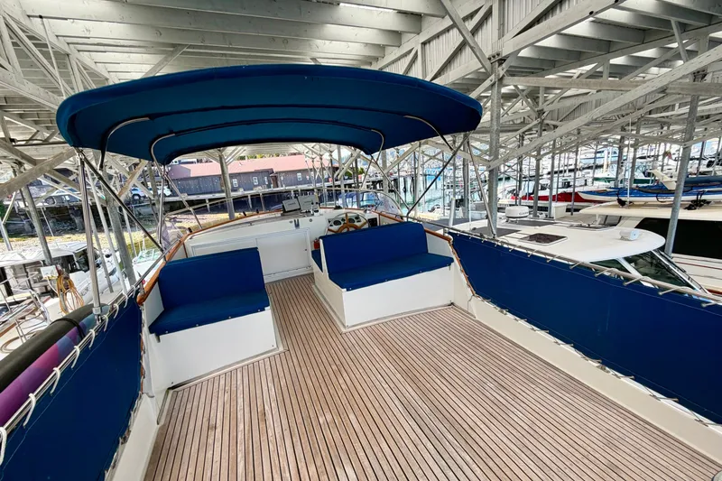 Slide: The Image of 1988 Grand Banks 42 Classic yacht with blue canopy and seating, docked in a marina. - 24