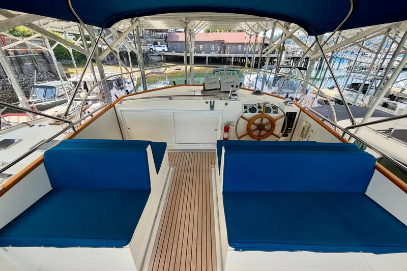 Slide: The Image of Flybridge of 1988 Grand Banks 42 Classic yacht with blue seating and wooden steering wheel. - 25