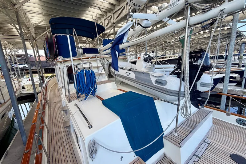 Slide: The Image of 1988 Grand Banks 42 Classic yacht with dinghy, docked under covered marina. - 22