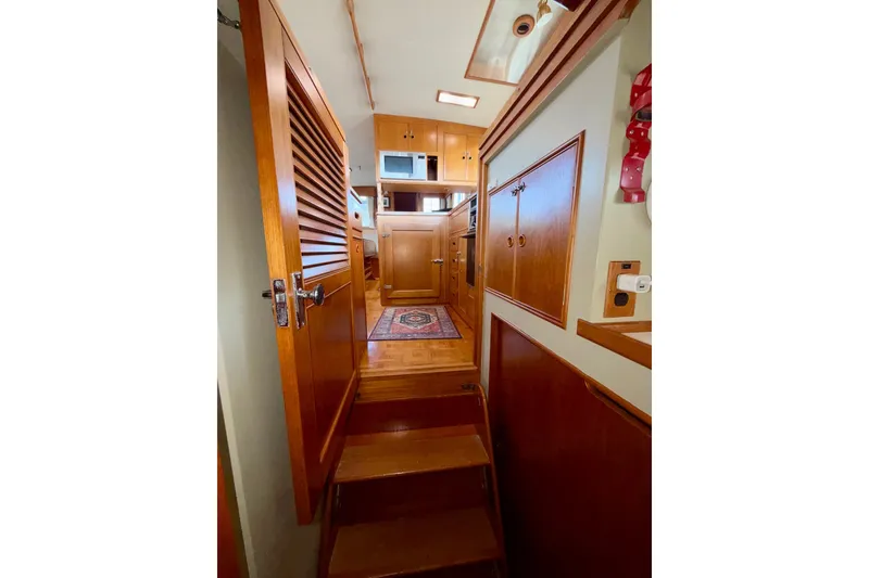 Slide: The Image of Interior of 1988 Grand Banks 42 Classic yacht, featuring wooden cabinetry and stairs. - 52