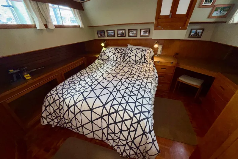 Slide: The Image of Cozy bedroom in 1988 Grand Banks 42 Classic yacht with geometric bedding and wooden furnishings. - 56