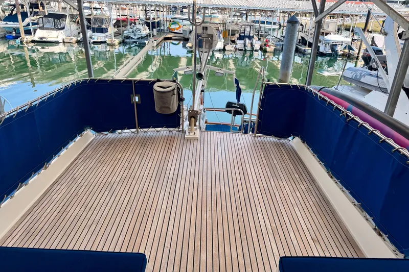 Slide: The Image of 1988 Grand Banks 42 Classic yacht deck with blue seating, docked in a marina. - 28