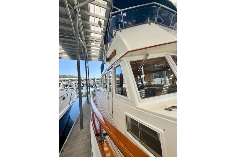 Slide: The Image of 1988 Grand Banks 42 Classic yacht docked under a covered marina. - 15