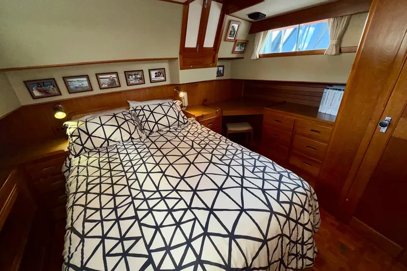 Slide: The Image of Cozy bedroom in 1988 Grand Banks 42 Classic yacht with geometric bedding and wooden furnishings. - 58