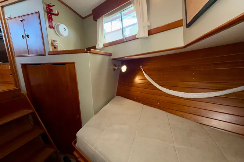 Slide: The Image of Cozy cabin interior of 1988 Grand Banks 42 Classic yacht with wooden paneling and bed. - 50