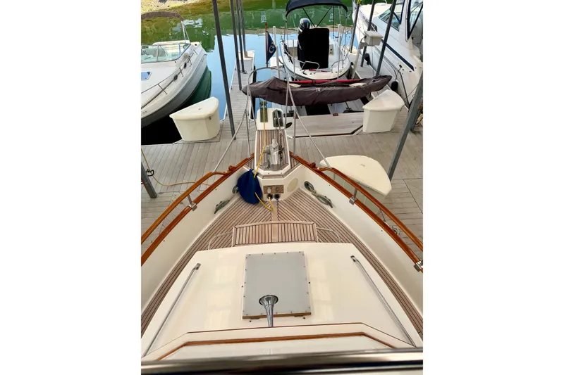 Slide: The Image of 1988 Grand Banks 42 Classic yacht docked, showcasing elegant wooden deck and marina surroundings. - 27