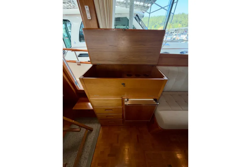 Slide: The Image of Interior of 1988 Grand Banks 42 Classic yacht with open wooden storage compartment. - 44