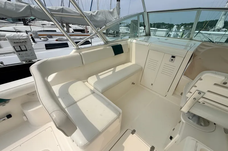Slide: The Image of 1999 Pursuit 2860 Denali boat interior with white seating and helm station. - 13