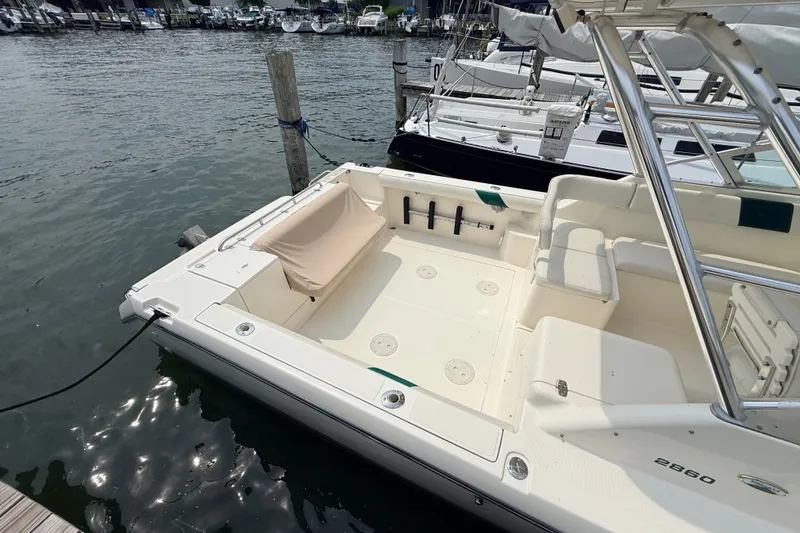 Slide: The Image of 1999 Pursuit 2860 Denali boat docked at marina, featuring spacious deck and seating area. - 5