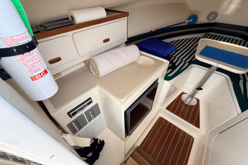 Slide: The Image of Interior of a 1999 Pursuit 2860 Denali boat with compact amenities. - 16