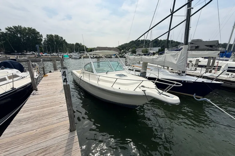 The Image of 1999 Pursuit 2860 Denali boat docked at a marina, surrounded by other vessels. - 1