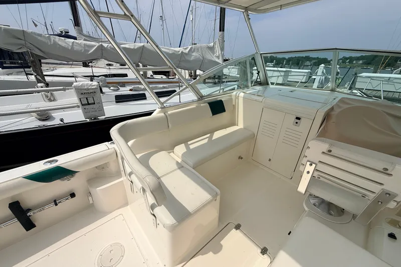 Slide: The Image of 1999 Pursuit 2860 Denali boat interior with seating and helm, docked at marina. - 6