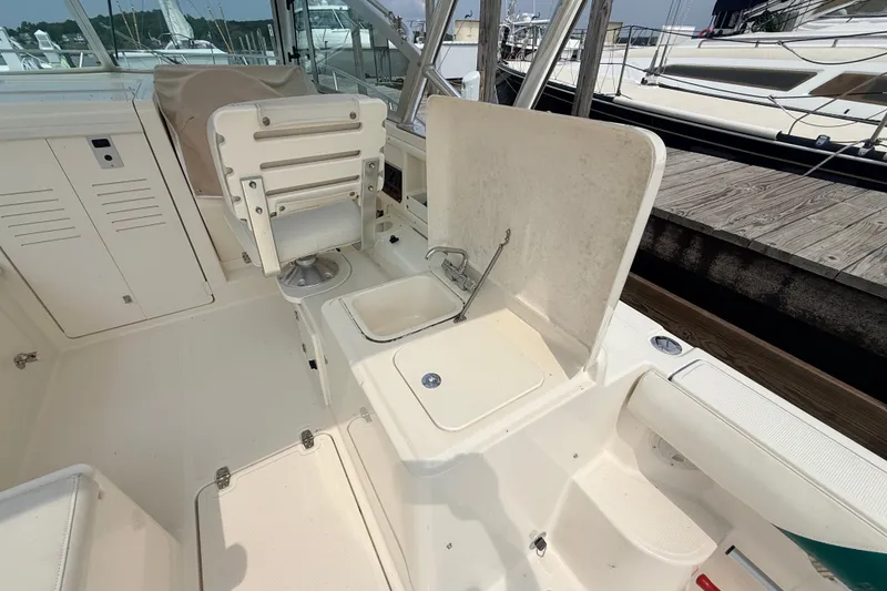 Slide: The Image of 1999 Pursuit 2860 Denali boat interior with seating and sink area. - 12