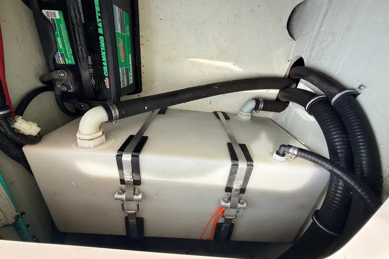 Slide: The Image of 1999 Pursuit 2860 Denali boat battery and storage compartment with hoses and wiring. - 20