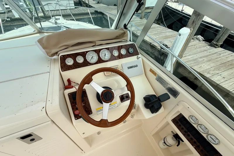 Slide: The Image of 1999 Pursuit 2860 Denali boat helm with wooden steering wheel and instrument panel. - 9