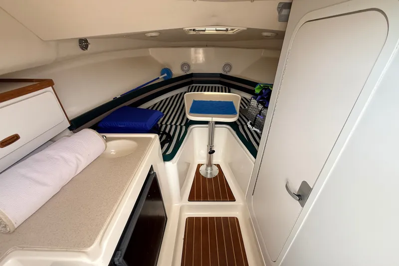 Slide: The Image of 1999 Pursuit 2860 Denali cabin interior with sink, seating, and storage. - 14