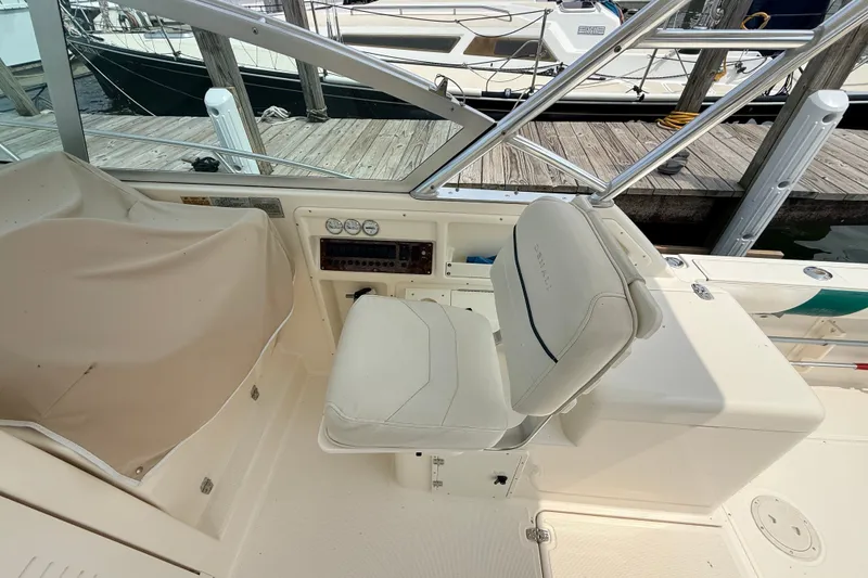 Slide: The Image of 1999 Pursuit 2860 Denali boat interior with helm seat and dashboard at dock. - 8