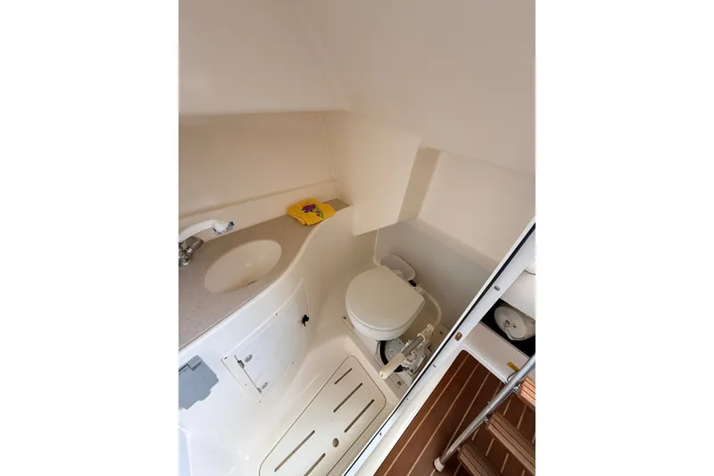 Slide: The Image of 1999 Pursuit 2860 Denali boat bathroom with sink, toilet, and storage. - 17