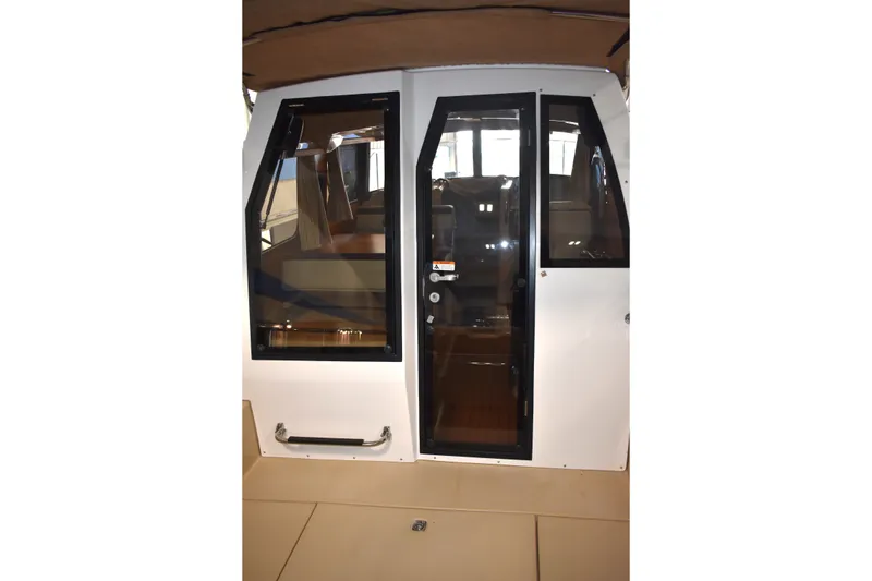 Slide: The Image of 2019 Ranger Tugs R-23 boat cabin entrance with glass doors and interior view. - 21