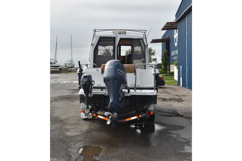 Slide: The Image of 2019 Ranger Tugs R-23 boat with Yamaha outboard motor, parked at a marina. - 1