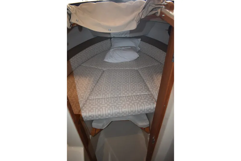 Slide: The Image of 2019 Ranger Tugs R-23 cabin interior with patterned bedding and pillow. - 36