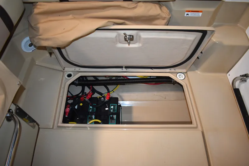 Slide: The Image of An open storage compartment in the floor of a Ranger Tugs R-23 boat reveals batteries and cables. - 20