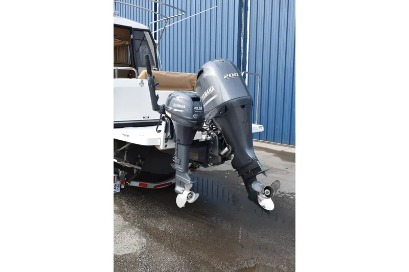 Slide: The Image of 2019 Ranger Tugs R-23 with Yamaha outboard motors, parked near a blue building. - 10