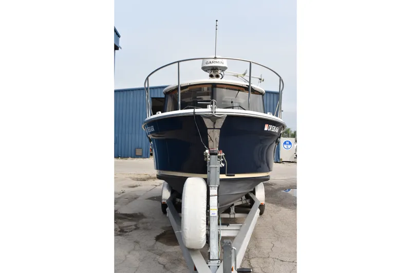 Slide: The Image of 2019 Ranger Tugs R-23 boat on trailer, front view, blue hull, parked outdoors. - 12