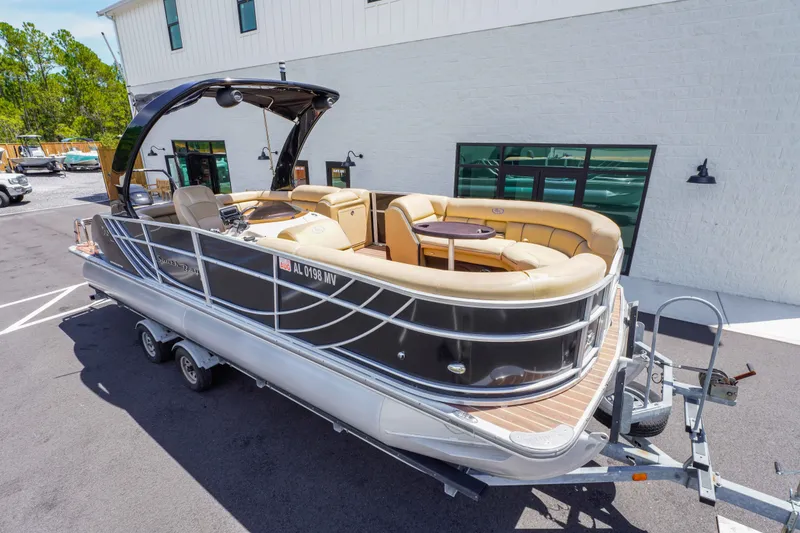 Slide: The Image of 2016 South Bay 724 SPORT DLX pontoon boat on trailer, parked outside a building. - 12