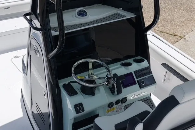 Slide: The Image of 2027 Tidewater 2500 Carolina Bay boat console with steering wheel and navigation controls. - 9