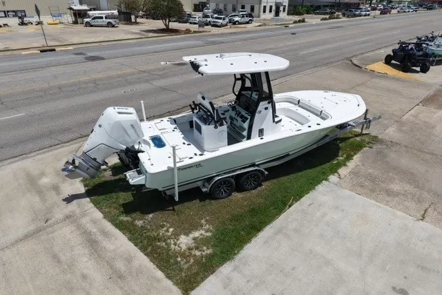 Slide: The Image of 2027 Tidewater 2500 Carolina Bay boat on trailer, parked on grass near a road. - 7