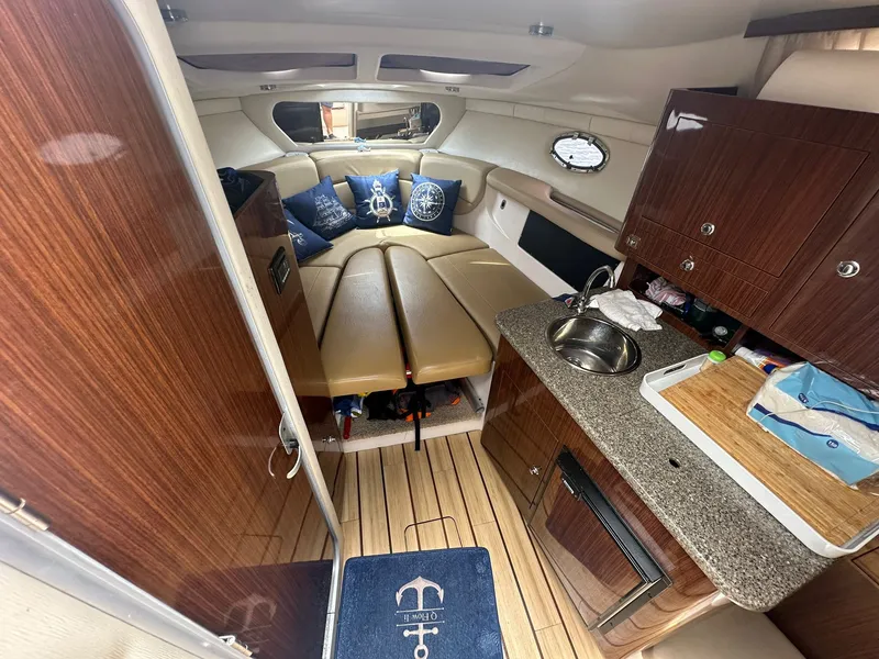 Slide: The Image of Interior of a 2014 Regal 30 Express with cozy cabin, wood flooring, and small kitchenette. - 24