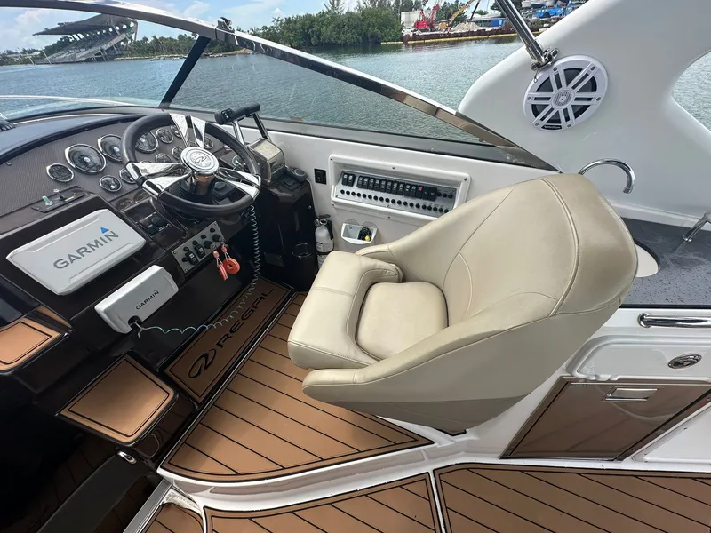 Slide: The Image of The cockpit of a 2014 Regal 30 Express with a beige leather seat and modern instruments. - 23