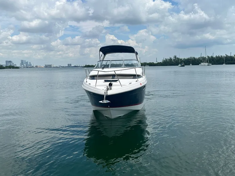 Slide: The Image of A 2014 Regal 30 Express boat on calm water with a cloudy sky in the background. - 2
