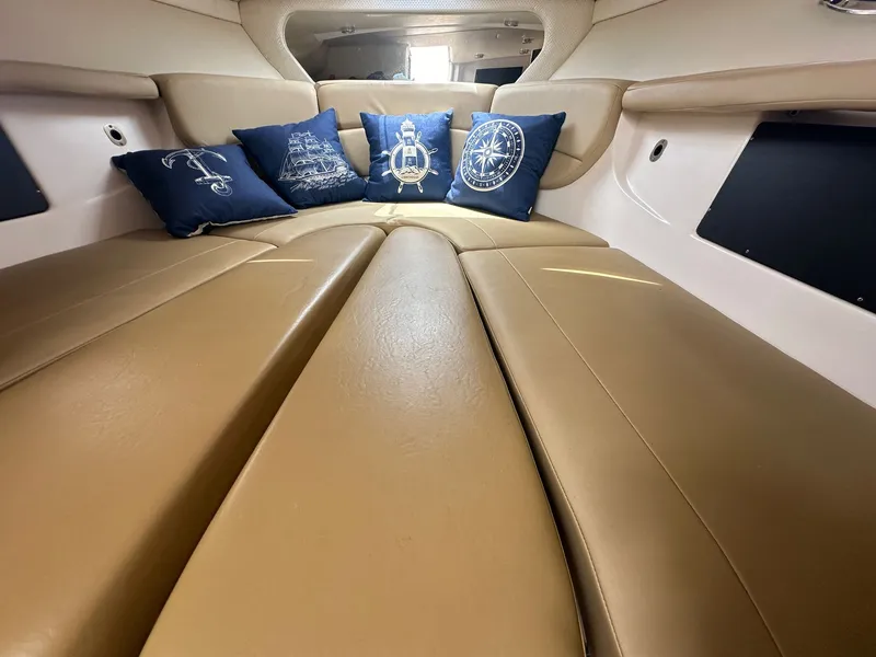 Slide: The Image of Interior of the 2014 Regal 30 Express with beige upholstery and decorative blue pillows. - 25